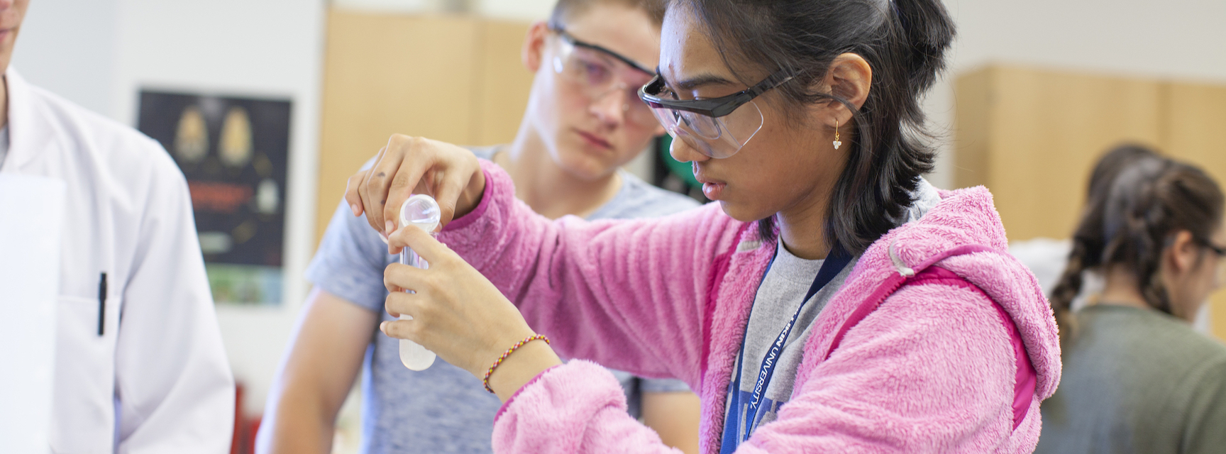 student measuring pouring fluid from a test tube