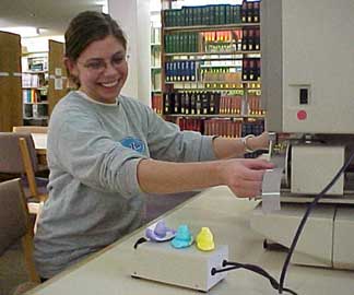 photo of Peeps seeking assistance with microfilm machine from library student worker