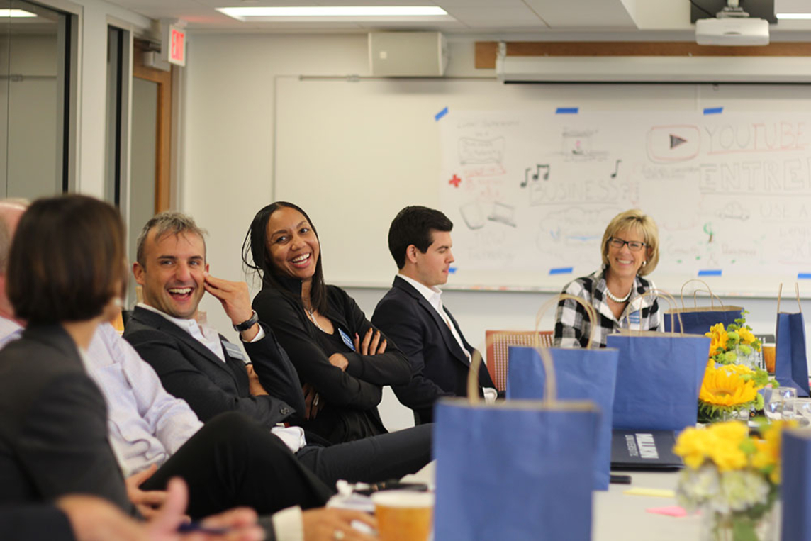 People sitting at a conference table smiling