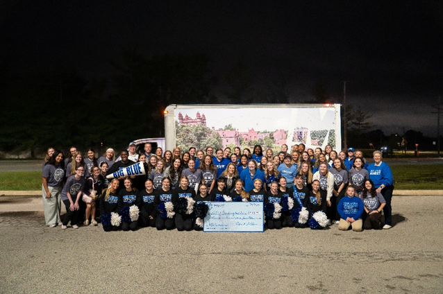 Approximately 75 individuals wearing Millikin University appear before a food delivery truck
