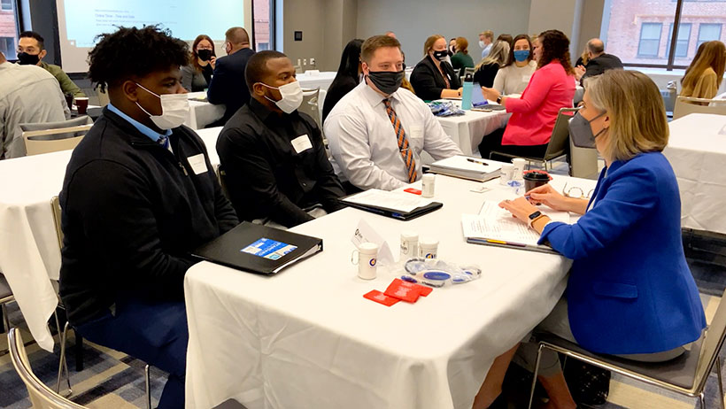 Students sitting at a table in a mock interview