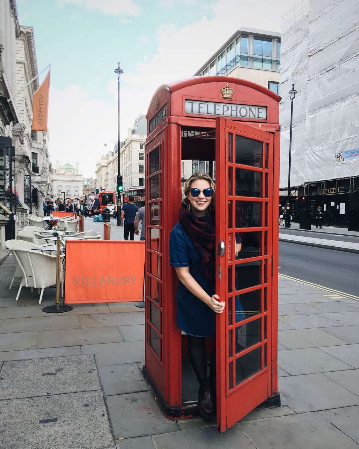 Student peeking out of a phonebooth