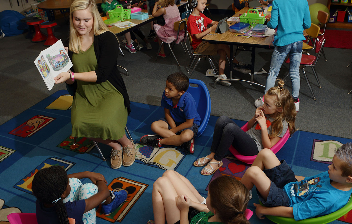 woman reading to kids on cute carpet