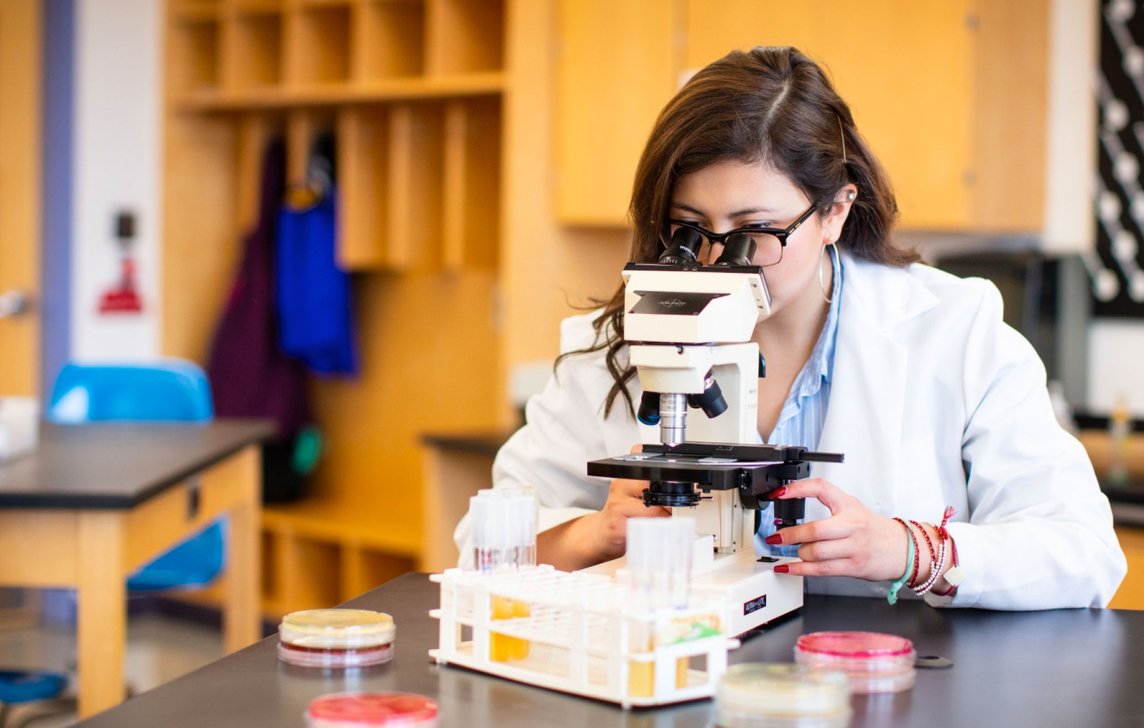 student using microscope