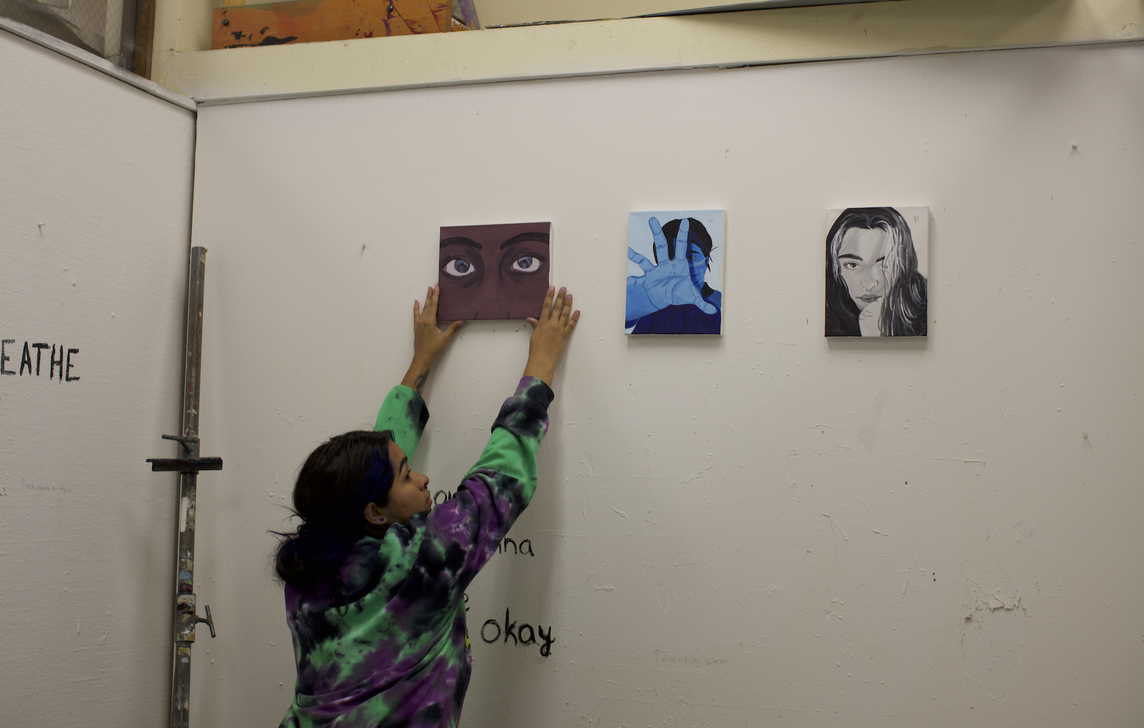 student hanging art