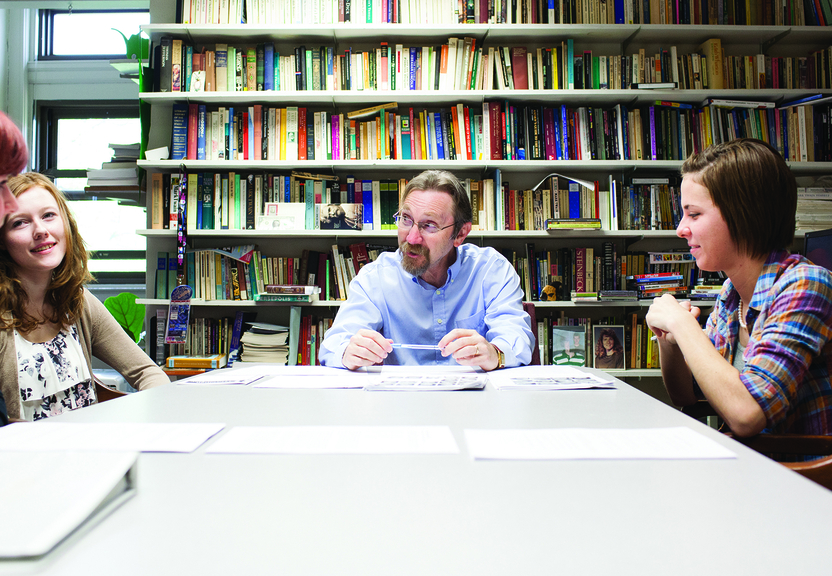 four students at a table talking