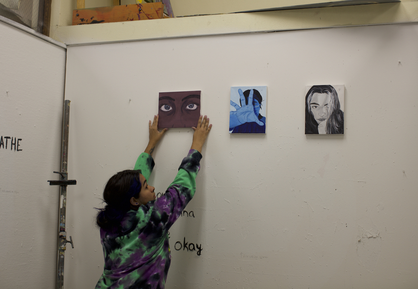 student hanging art