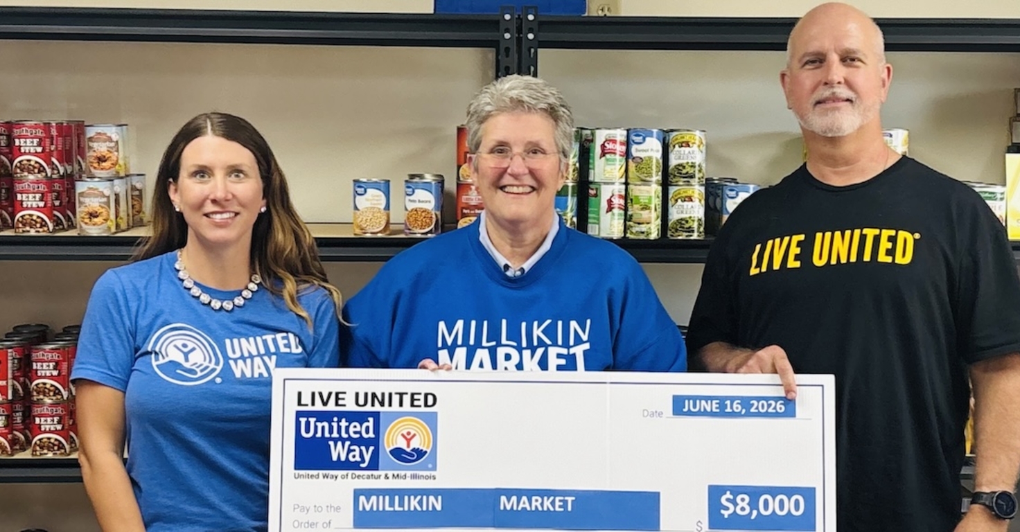 3 people presenting check for millikin market