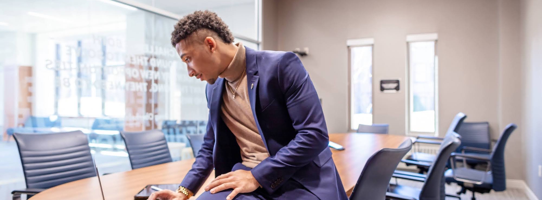 Student sitting on desk looking at laptop