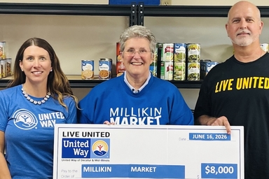 3 people presenting check for millikin market
