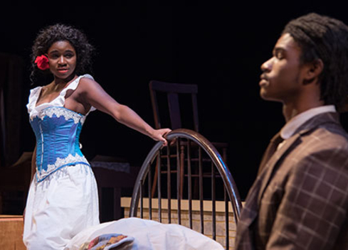 woman on stage holding railing with man closing his eyes