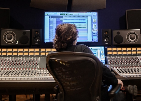 Student sitting at sound board