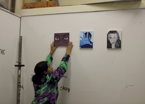 student hanging art