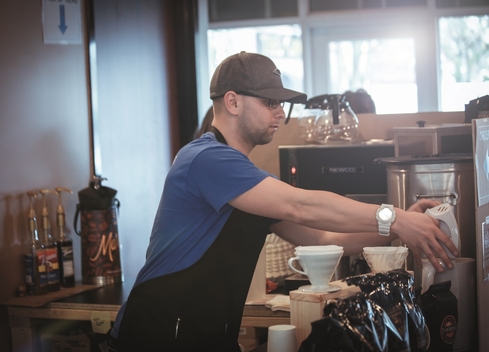 worker brewing coffee