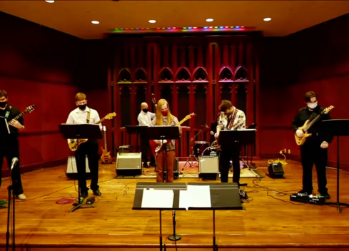 Group of students playing guitar on stage